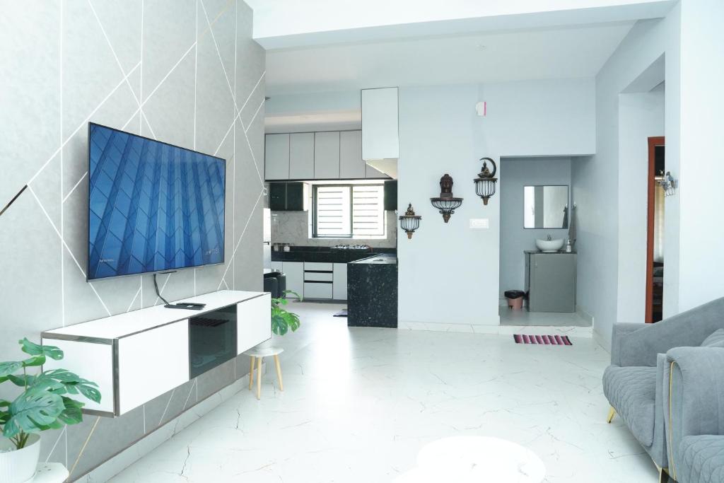 a living room with a tv on a wall at Sukruthi service apartment 3BHK in Mangalore