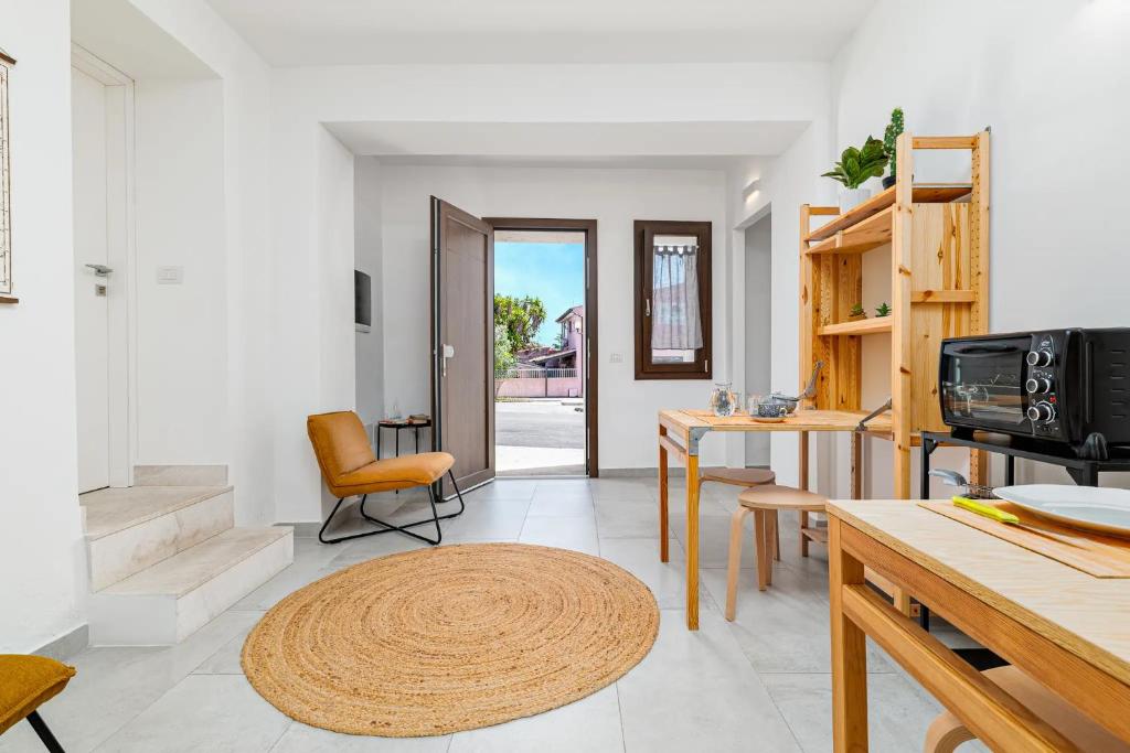 a living room with a table and a kitchen at Ghjlgolu Suites - Essential Stay in Monte Petrosu