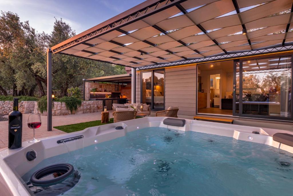 a hot tub in the backyard of a house at Olive Spa Oasis with Private Jacuzzi and Summer Kitchen in Orasac