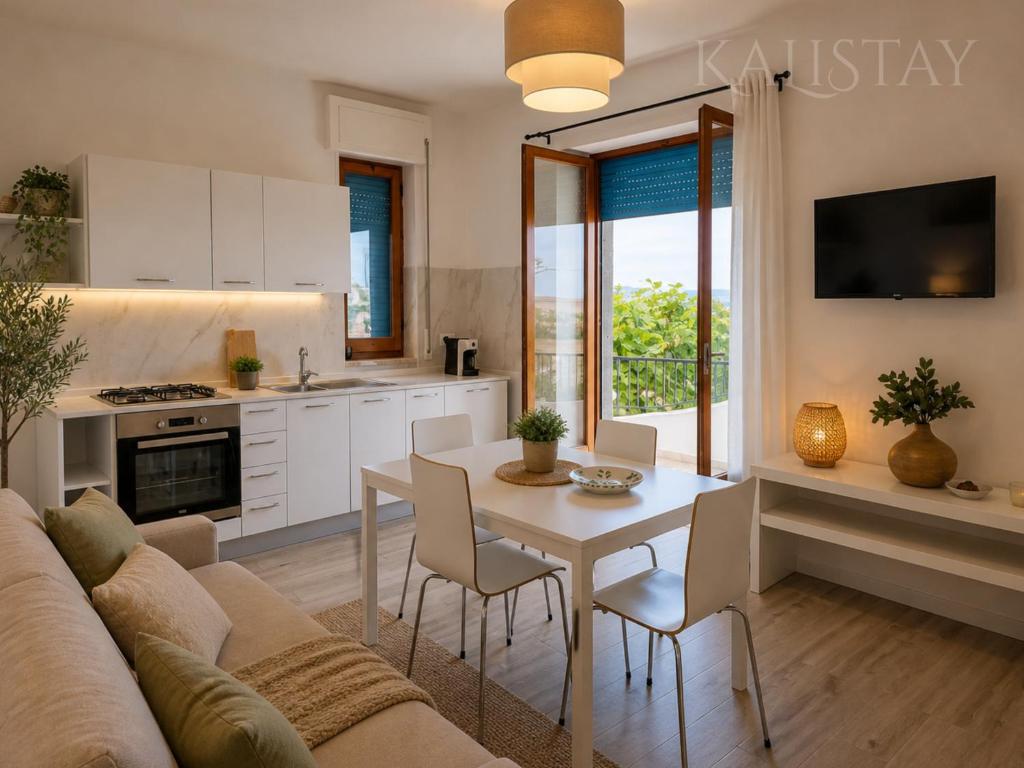 a kitchen and living room with a couch and a table at Casa Francesca Appartamento a 200m dal mare in Torre Canne