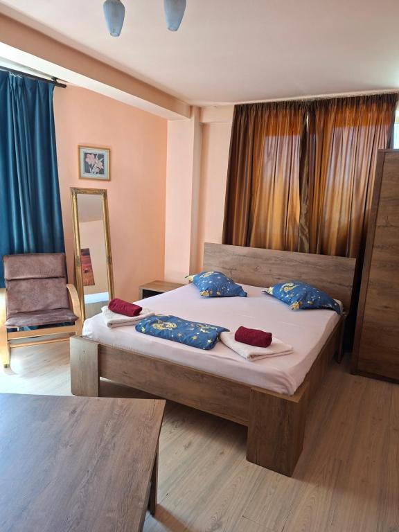 a bedroom with a bed with blue pillows on it at Pensiunea Nicol Tulcea in Tulcea