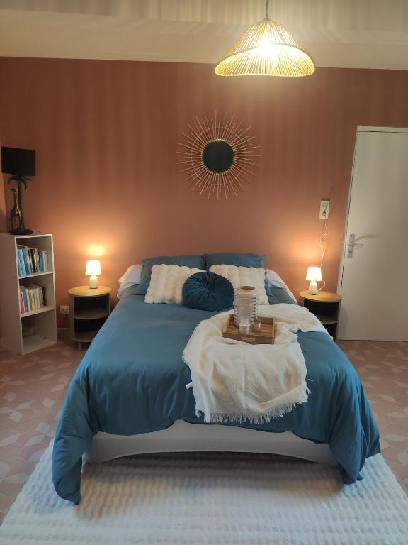 a bedroom with a large bed with a table on it at Le clos du Souffle in Saint-Ouen-sous-Bailly