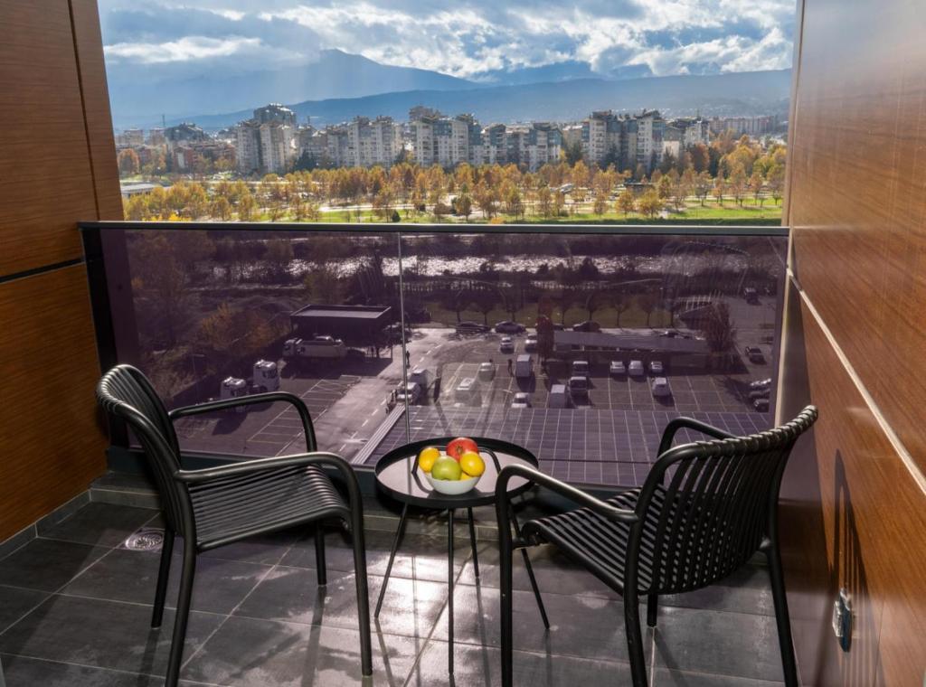 a balcony with a table and chairs and a view at Hotel Cube 55 - Business Suites in Skopje