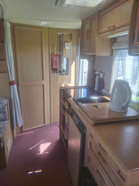 a kitchen with a sink and a stove top oven at Park house farm caravan 2 in Richmond