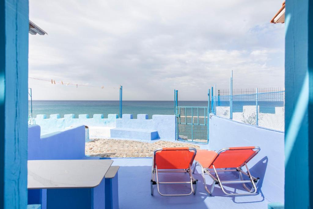 two chairs and a table on a balcony with the beach at Villa Sissy in Kerames