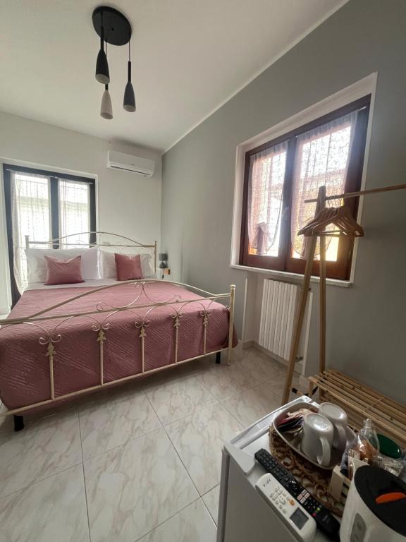 a bedroom with a bed and two windows at Piccola Mansarda in Parghelia