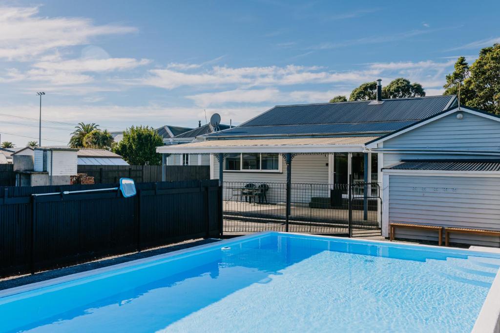 a swimming pool in front of a house at Marsden Manor - Spacious house with large pool in Greymouth
