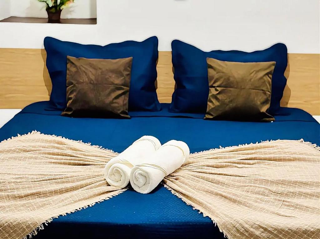 a blue bed with towels and pillows on it at Voer Jequitibá Hospedaria in Jequitibá