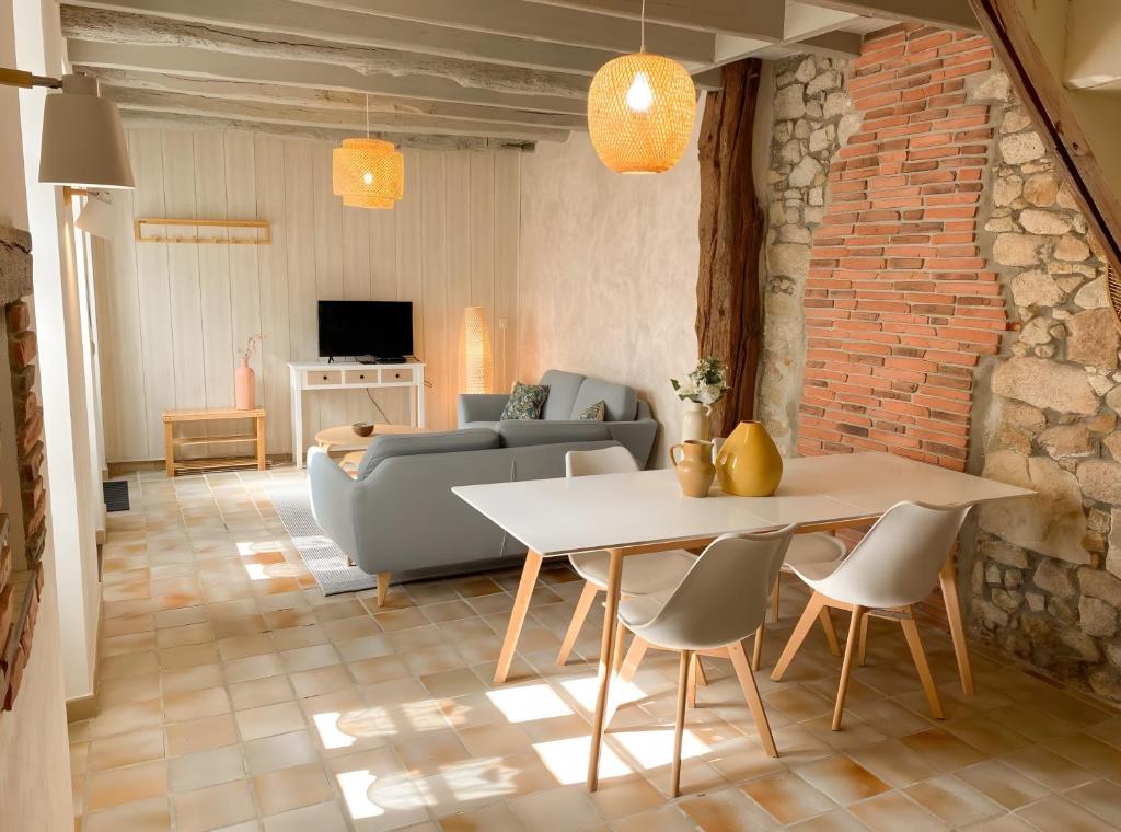a living room with a table and a couch at Le Logis de la Forge-10min puydufou in Mortagne-sur-Sèvre
