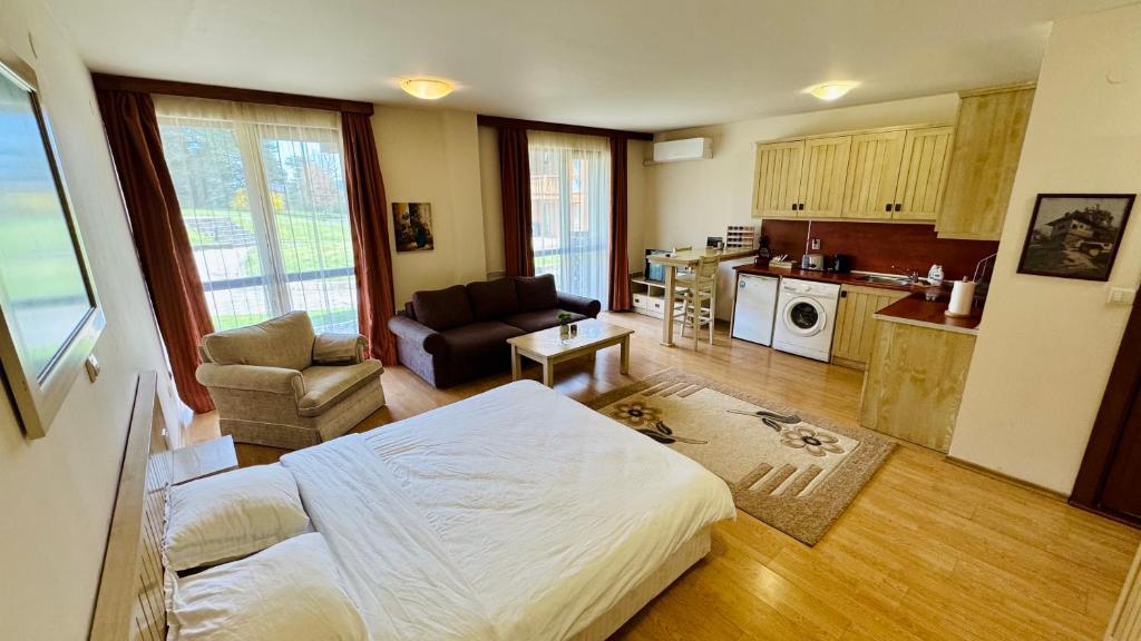 a living room with a bed and a kitchen at студио Пирин in Razlog