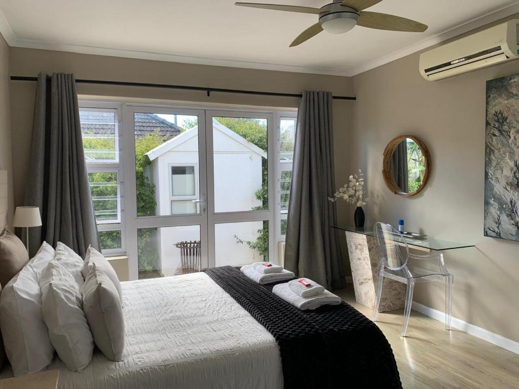 a bedroom with a bed and a large window at The Cottage on Alphen in Heathfield