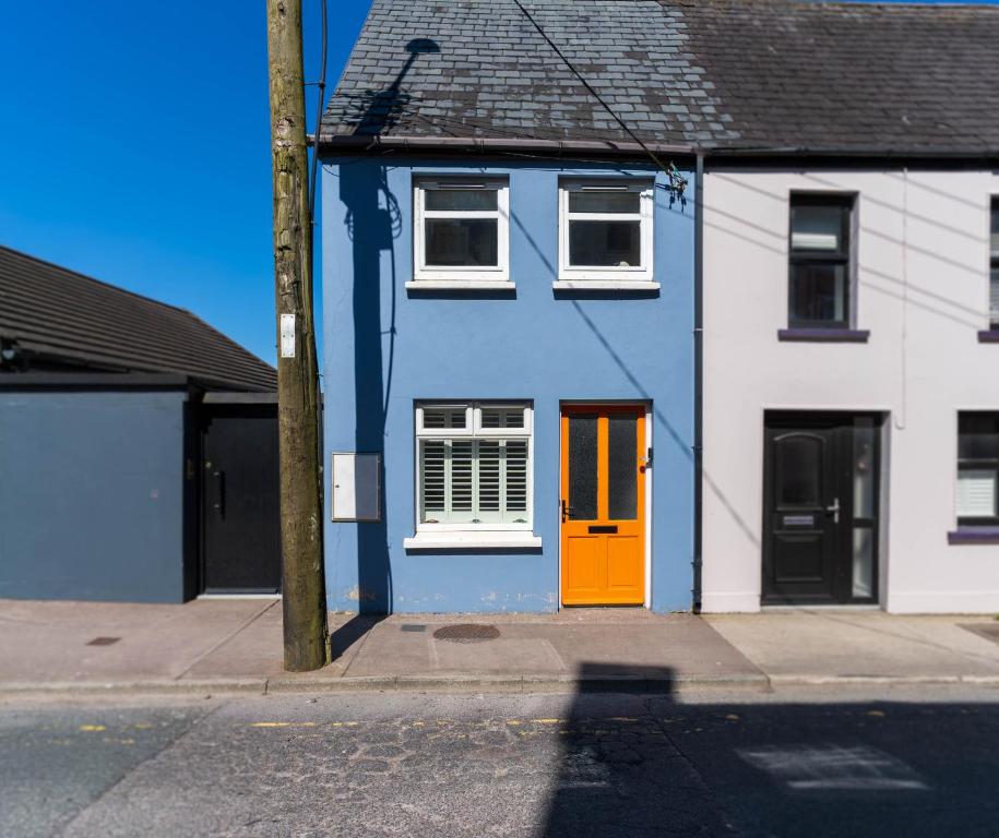 a blue and white house with a orange door at Hidden Gem Townhouse - Cahersiveen in Cahersiveen