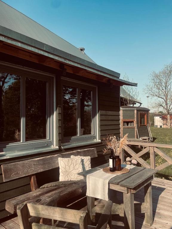 a table and bench on a porch of a house at Tiny House Jovana in Kröpelin