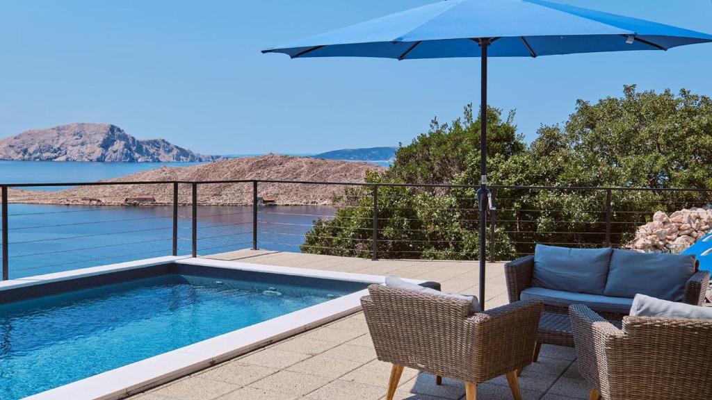 a swimming pool with chairs and an umbrella at House Vissum by Villas Guide in Lukovo