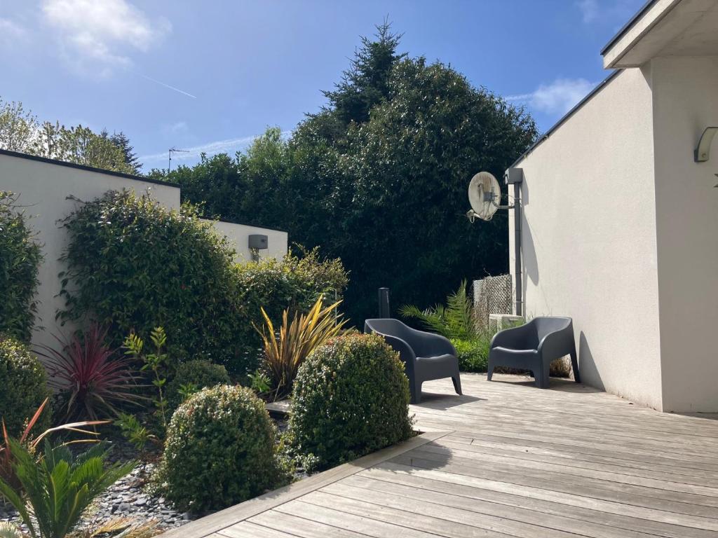 a patio with two chairs and a wooden deck at Villa Les Lodges Terre et Mer in Concarneau