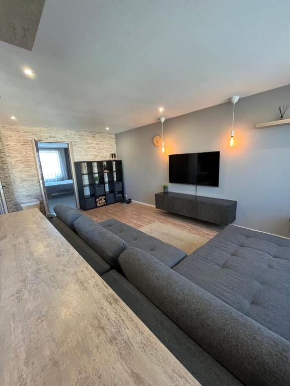 a living room with a large couch and a flat screen tv at Dzivoklis ar saunu in Rēzekne