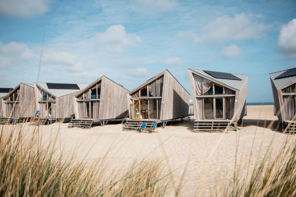 a row of wooden huts on the beach at Breezand Beachhouses in Vrouwenpolder
