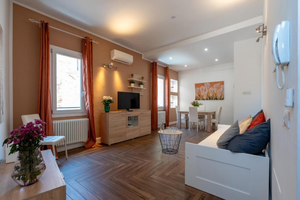 a living room with a couch and a tv at Gold Apartment in Ferrara