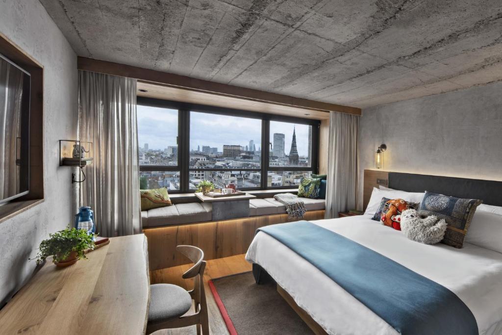 a hotel room with a bed and a large window at Treehouse Hotel London in London