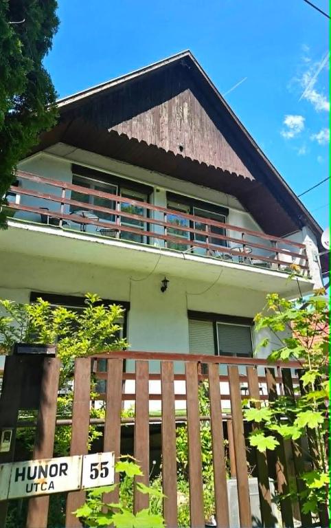 a house with a wooden fence in front of it at Balatoni HUNOR Vendégház in Balatonvilágos