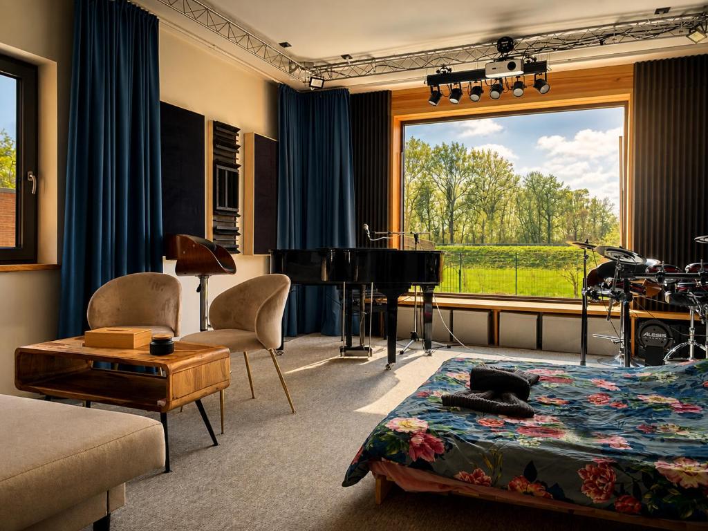 a living room with a piano and a room with a couch at Apartmán & House Big Win Mělník in Mlazice