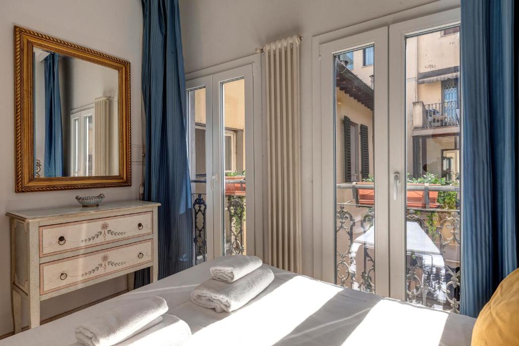 a bedroom with a bed and a mirror and a window at Taddeo Apartement by Mamo Florence in Florence