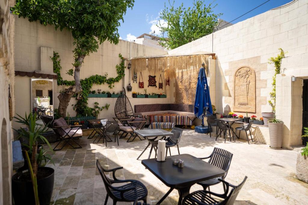 a patio with tables and chairs and umbrellas at sermest house in Urfa