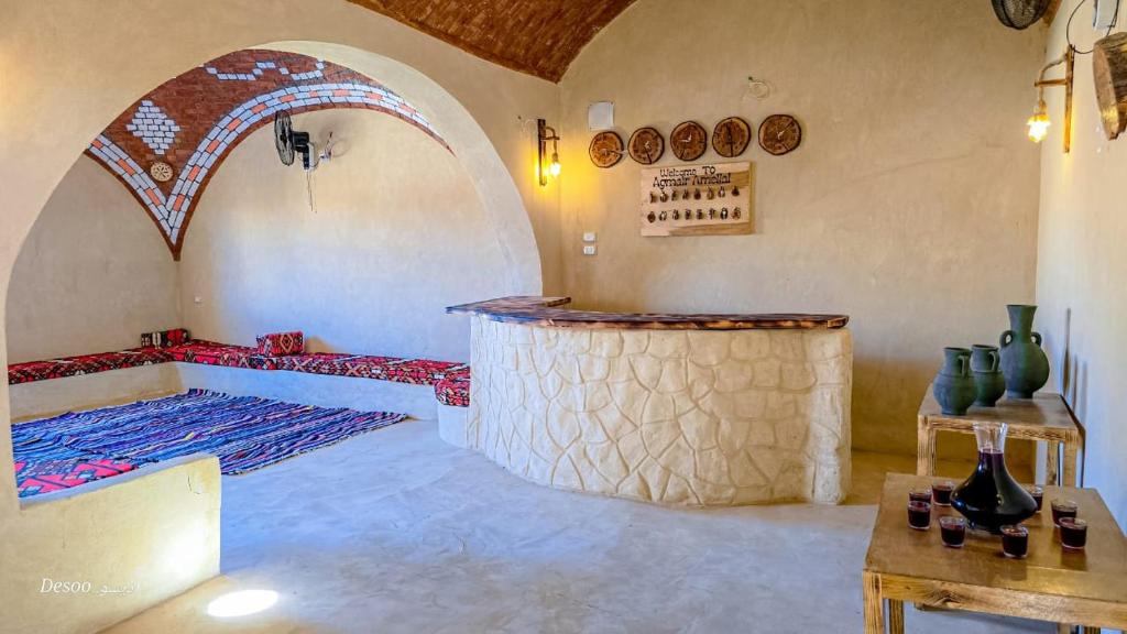 a room with a bed and a table with vases at Agmair Amellal in Siwa