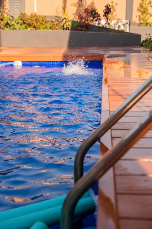 a swimming pool with a hose in the water at Appartements Quartier Kabulameshi - Lubumbashi in Lubumbashi