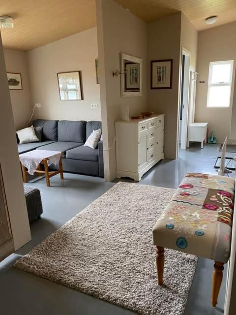 a living room with a couch and a rug at Between sea and big mountains in Leirá