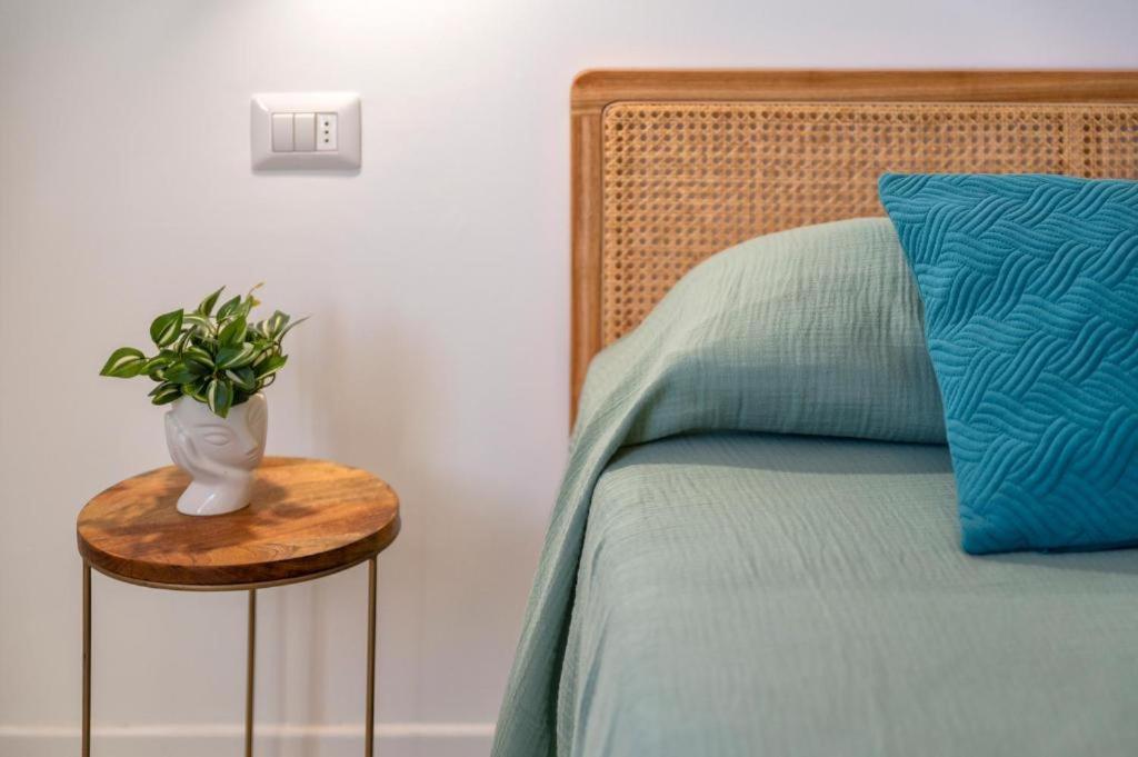 a bedroom with a bed with a vase on a table at Opera Rooms Alghero in Alghero