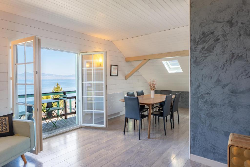 a dining room with a table and chairs and a balcony at Waterfront in Lugrin