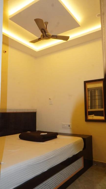 a bedroom with a bed with a ceiling fan at Hotel vasaavi Rameswaram in Rāmeswaram