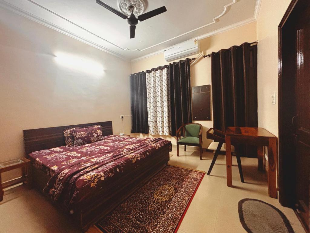 a bedroom with a bed and a chair and a desk at The Bel - Monte Stays in Panchkula