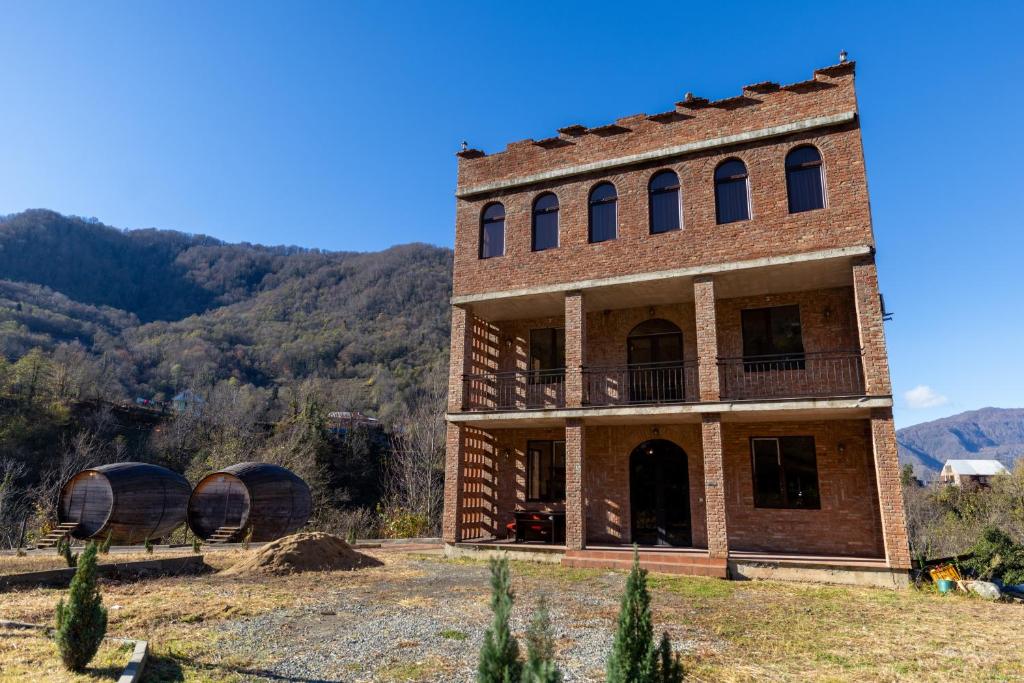 an old building with two wine barrels in front of it at Hotel Chateau Ochia in Koromkhet'i