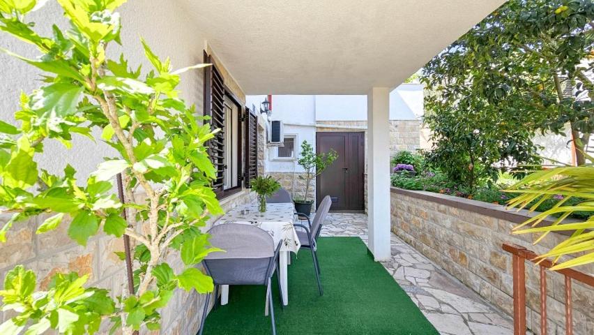 a dining table and chairs on a patio with plants at Ivanka Studio in Dajla