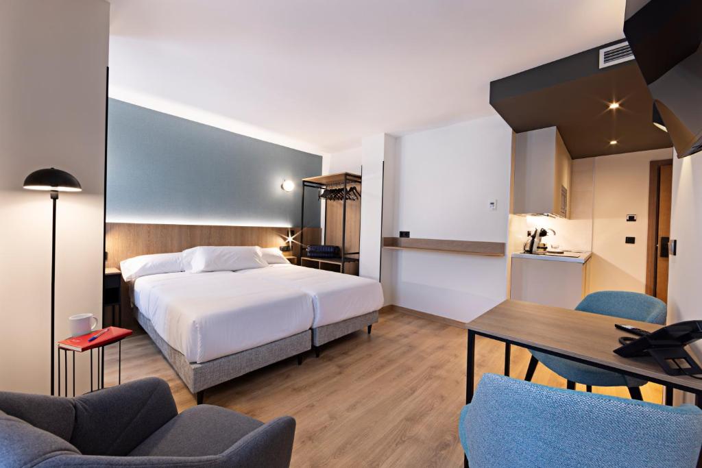 a hotel room with a bed and a table and chairs at Colón 27 in Palencia