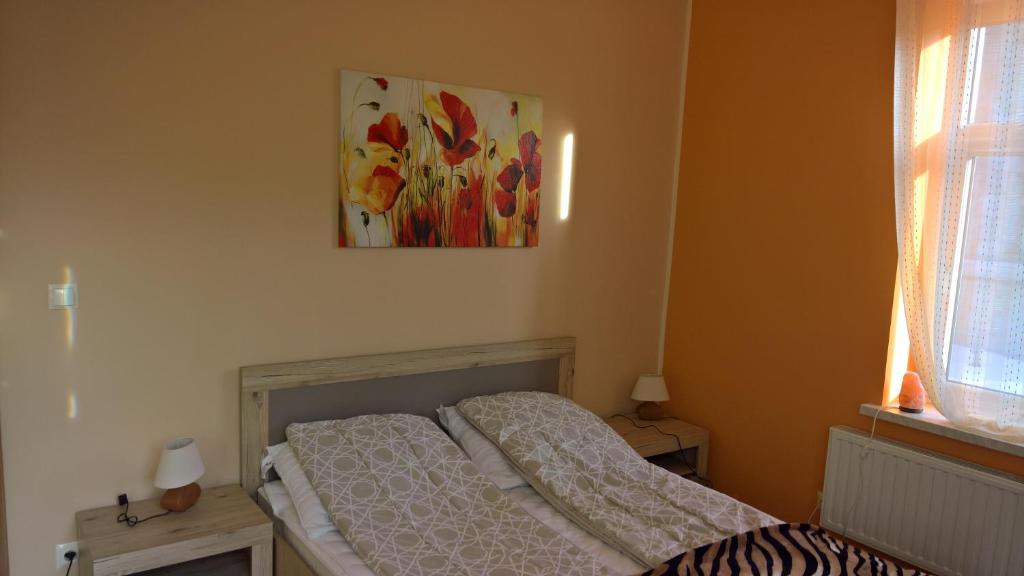 ロンデク・ズドルイにあるCztery pory rokuのベッドルーム1室(ベッド2台付)が備わります。壁には絵画が飾られています。