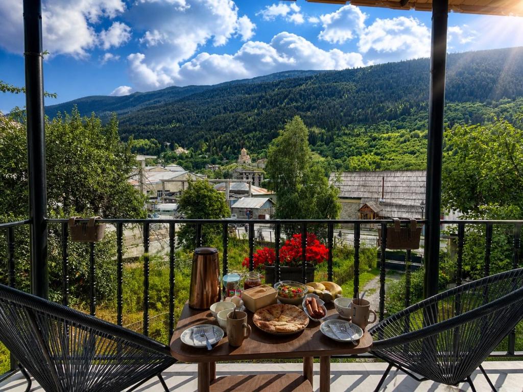 a table and chairs on a balcony with a view at Mamukas Guesthouse in Mestia