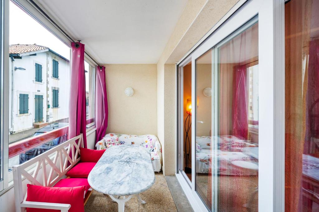a small room with a red couch and a window at Plein soleil, Capbreton in Capbreton