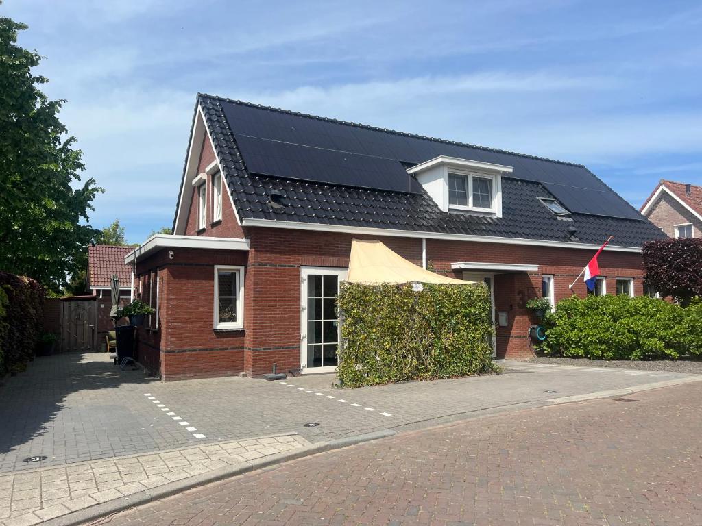 a red brick house with a solar roof at Etoile aan Zee in Vrouwenpolder