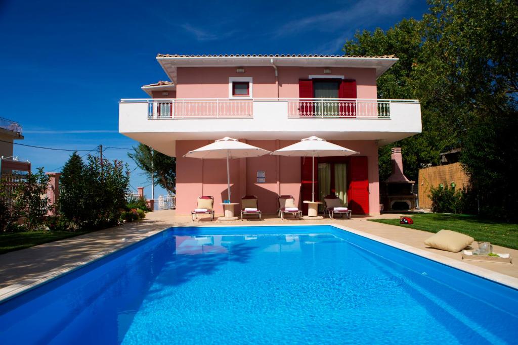 a villa with a swimming pool in front of a house at Exanthia Villas in Exanthia