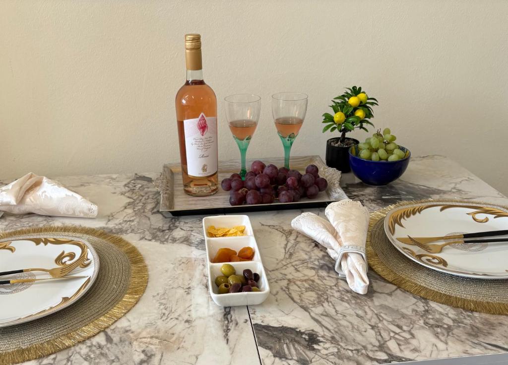 a table with a bottle of wine and wine glasses at Krasi Apartments in Perla Complex in Pomorie