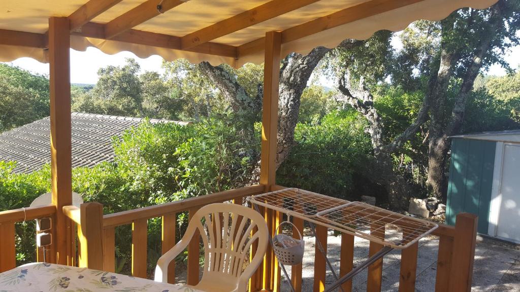 a porch with a table and chairs and trees at Mobilhome Rico in Gassin
