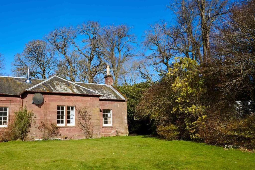 an old brick house with a grass yard at Laura's House in Coupar Angus