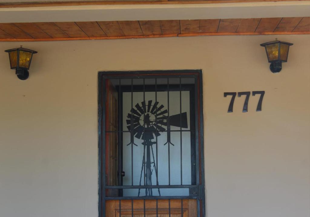 a door with a windmill on the side of a building at Vir Oulaas Guesthouse in Nieuwoudtville