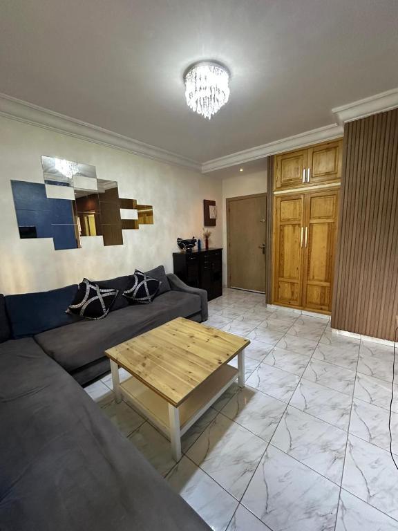 a living room with a couch and a table at Apparemment TAMARIS in Dar Bouazza