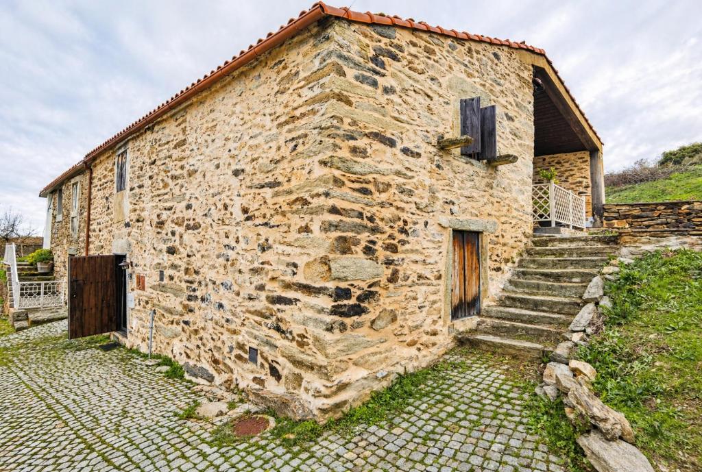 an old stone building with stairs next to it at Casas de Xisto in Mogadouro