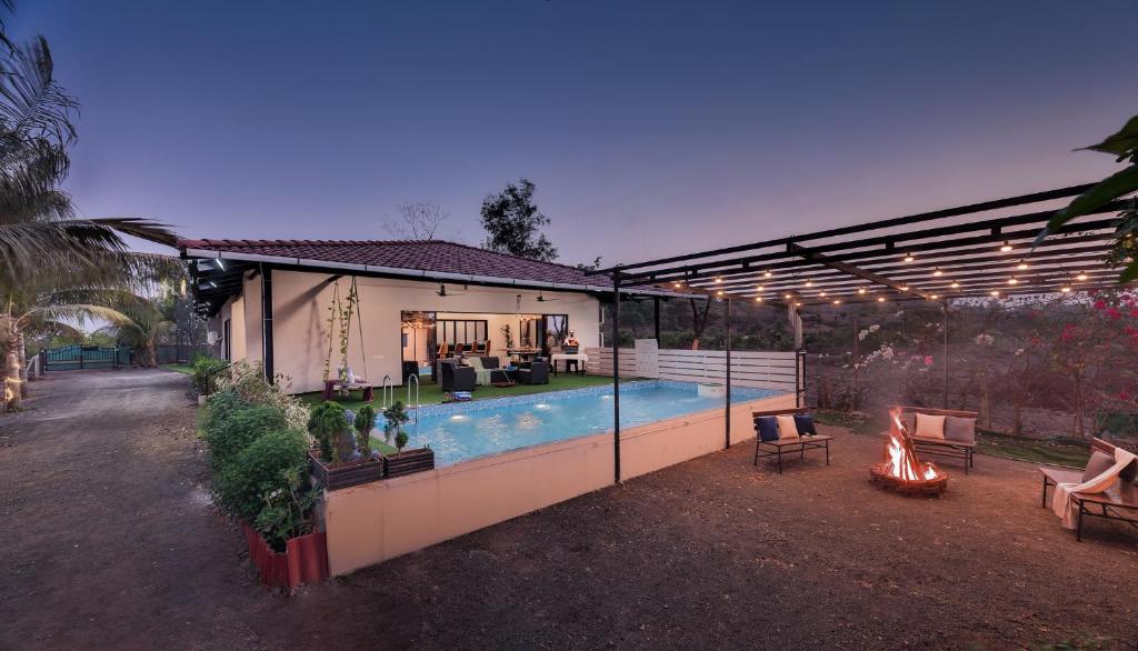 a house with a swimming pool and a fire pit at SaffronStays Ivy Courtyard - 5 bedroom & Veg Only Villa in Khopoli in Jambhulpāda