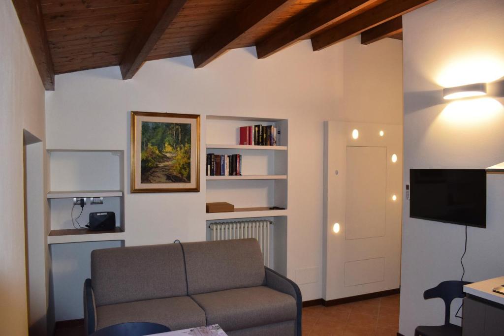 a living room with a couch and a tv at Il Loft Arona Centro, Le Dimore del Corso in Arona